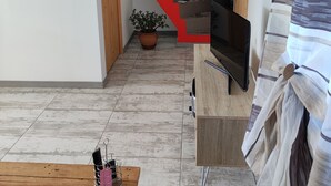 Un salon avec une table basse en bois, un téléviseur et un escalier menant à une autre pièce.