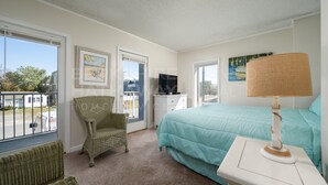 A bedroom with a bed, a chair, a television, and a window with a view of the outside. - 2-A DELANO CONDO - OCEAN BLOCK-1406 Coastal Hwy, Dewey Beach- DOG FRIENDLY! (Dewey Beach)