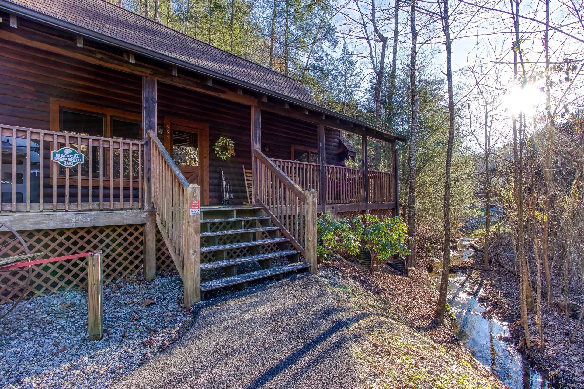 A wooden cabin with a porch, steps, and a sign reading "MAGICAL MOMENTS 260".