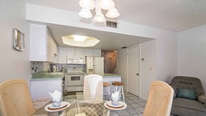 Un espacio habitable compacto con kitchenette, comedor y sofá.