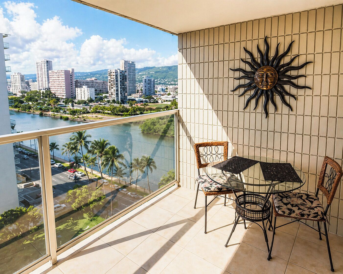 A balcony with a city view, a table with chairs, and a decorative sun wall.
