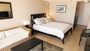 A bedroom with a bed, a sofa, a small table, and a chair. - Clean studio at the heart of Waikiki!! (Honolulu)