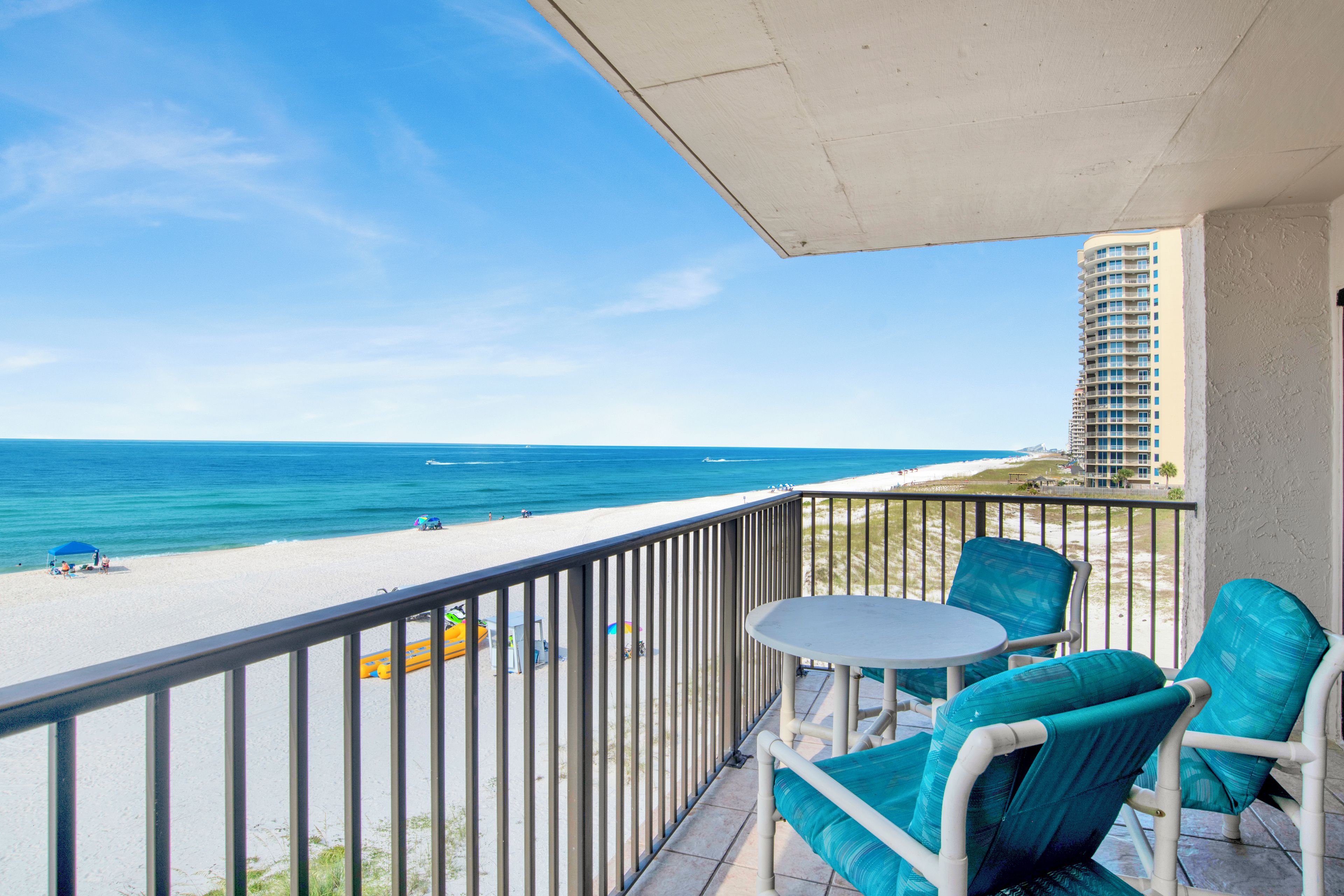 A balcony with a view of the beach and ocean.