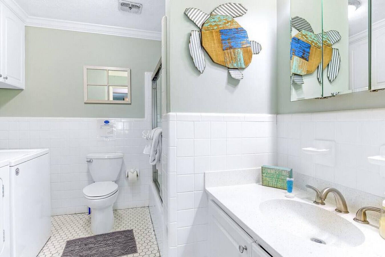 Un baño con inodoro, lavamanos y espejo.