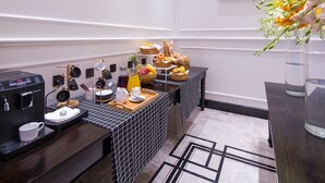 A breakfast setup with a coffee machine, breakfast items, and a vase of flowers. - The Bamboo Hotel Hong Qiao Airport (Shanghai)