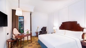 A hotel room with a large bed, a desk with a chair, a television, and a window with curtains. - The Bamboo Hotel Hong Qiao Airport (Shanghai)