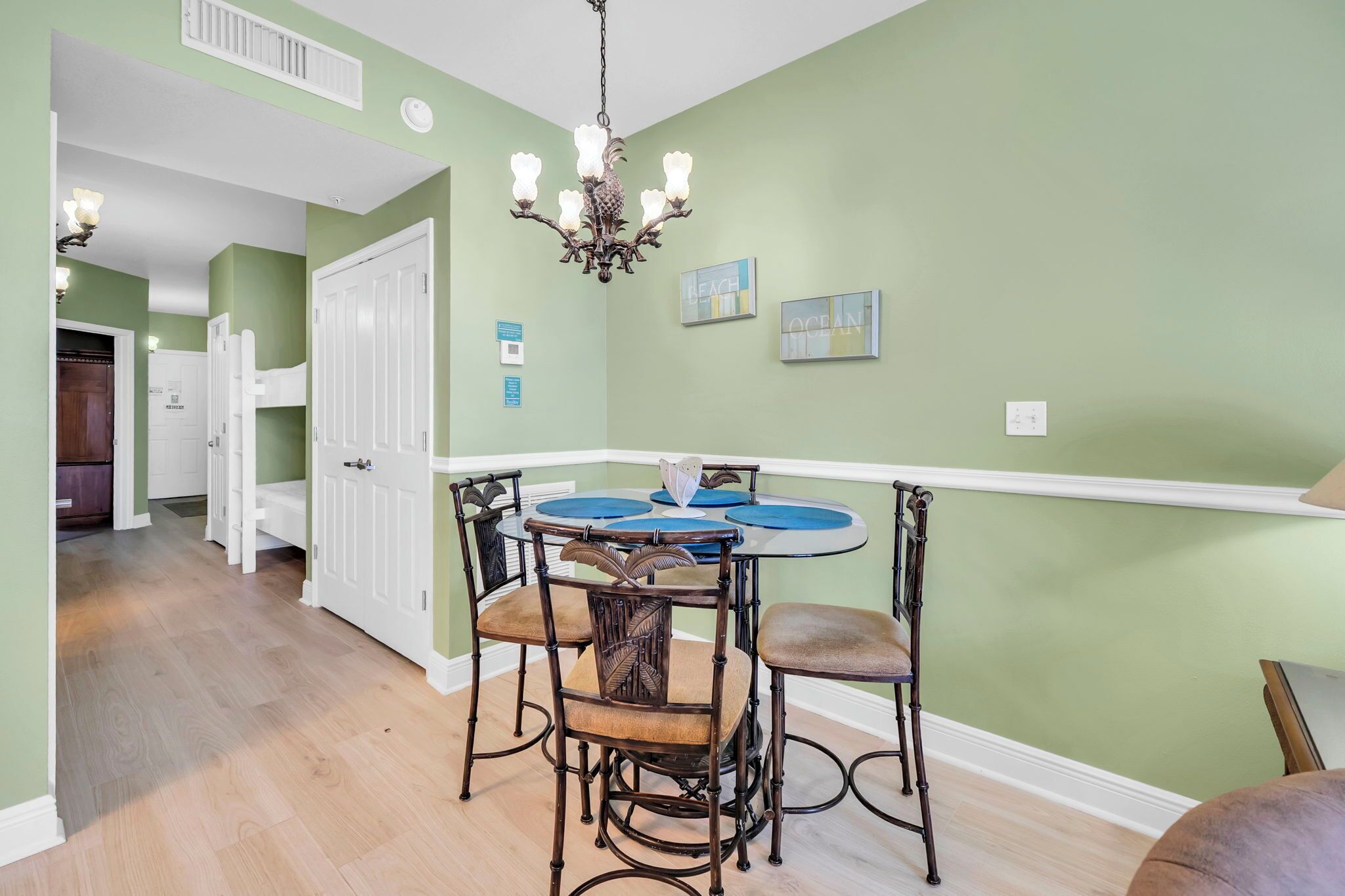 A dining area with a round table, chairs, and a chandelier.