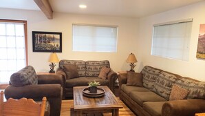 A cozy living room with two sofas, a wooden coffee table, and two lamps.