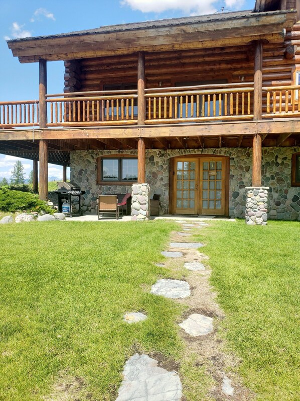 A log cabin with a stone exterior, a covered porch, and a stone pathway leading to the entrance. - 2 BD, 2B with Jet Bath Tub, Sauna, Sleeps 6, 2 minutes from West Glacier (West Glacier)