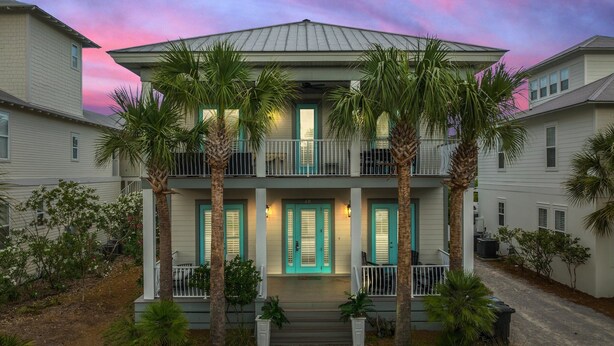 A two-story building with a balcony, surrounded by palm trees and a paved driveway. - Forever Summer: Discover Your Happy Place! (Rosemary Beach)