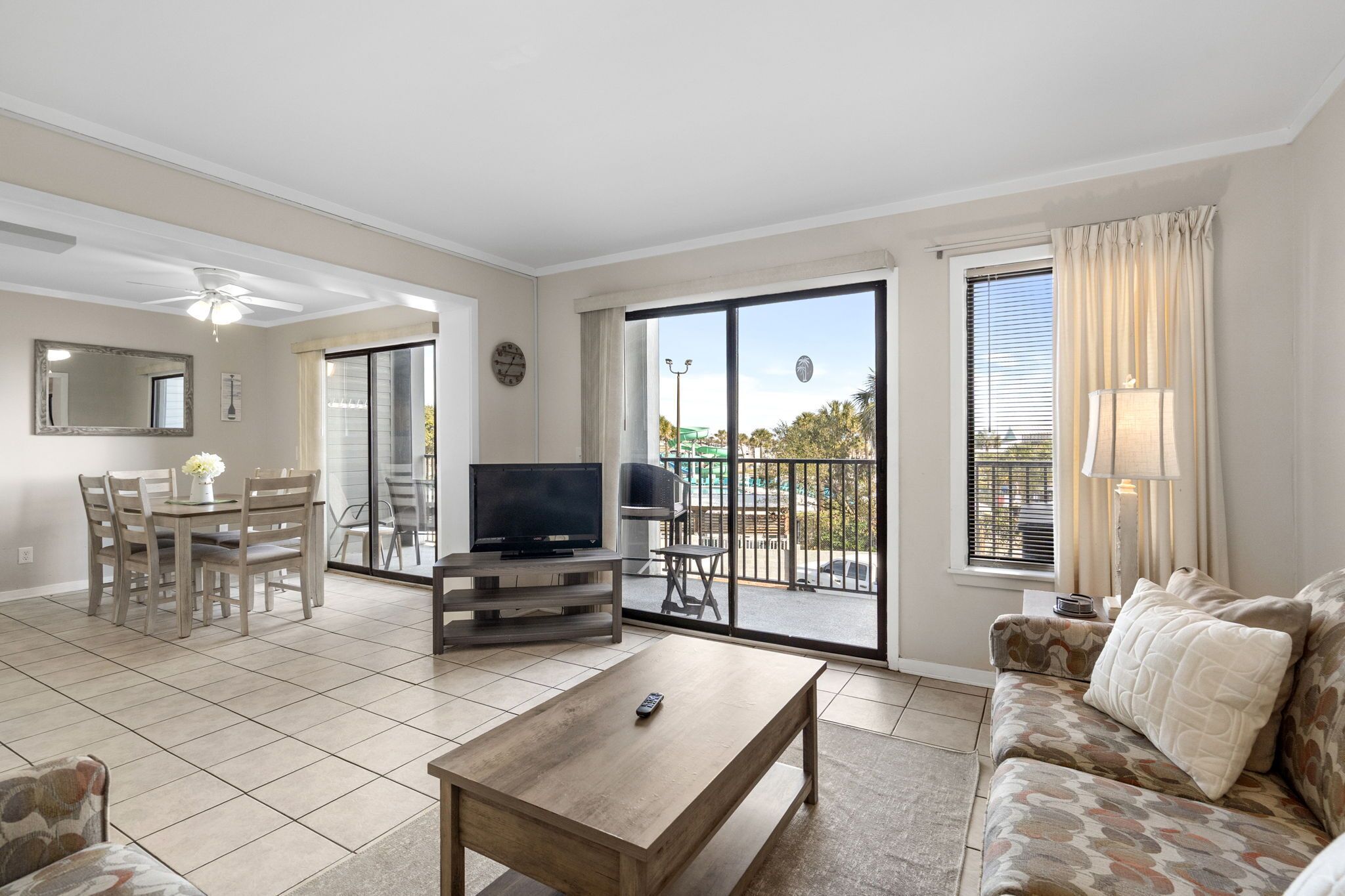 A spacious living area with a dining table, sofa, and TV.