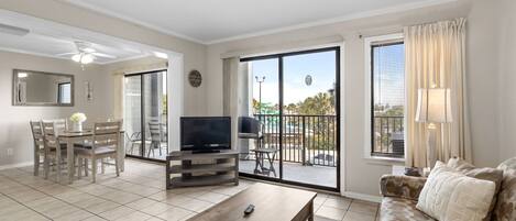 A spacious living area with a dining table, sofa, and TV.