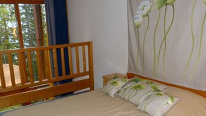 A bedroom with a wooden bed frame, a single bed, and a window with a view of trees. - Duplex 2-room, sleeps 6, ski-in/ski-out, Arc 1800, pets allowed (Les Arcs 1800)