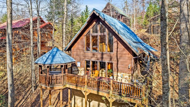 Eine Hütte mit Balkon und einer überdachten Sitzgruppe im Freien.
