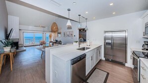 A modern kitchen with a large island, stainless steel appliances, and a view to the outside. - A17 Villas of Clearwater Beach Gulf-Front Condo (Clearwater Beach)