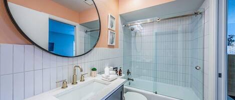 Un baño con lavamanos, inodoro y ducha.
