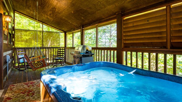 A hot tub in a wooden cabin with a porch, a grill, and a rocking chair. - ER17 - The Perfect Getaway | Great location - Close to town! (Pigeon Forge)