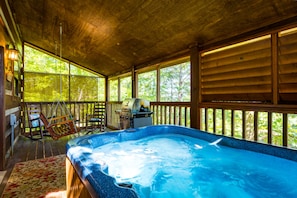 A hot tub in a wooden cabin with a porch, a grill, and a rocking chair. - ER17 - The Perfect Getaway | Great location - Close to town! (Pigeon Forge)