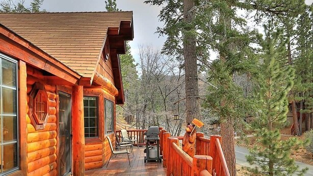 A log cabin with a deck, a grill, and a view of the surrounding forest. - Columbine Oak Retreat- Log Style Cabin W/ Spa (Big Bear City)