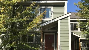 A two-story building with a red door, a wooden staircase, and a small porch. - Topnotch Resort, Stowe. Luxury 2/2 Resort Home just steps from the Spa.  (Stowe)