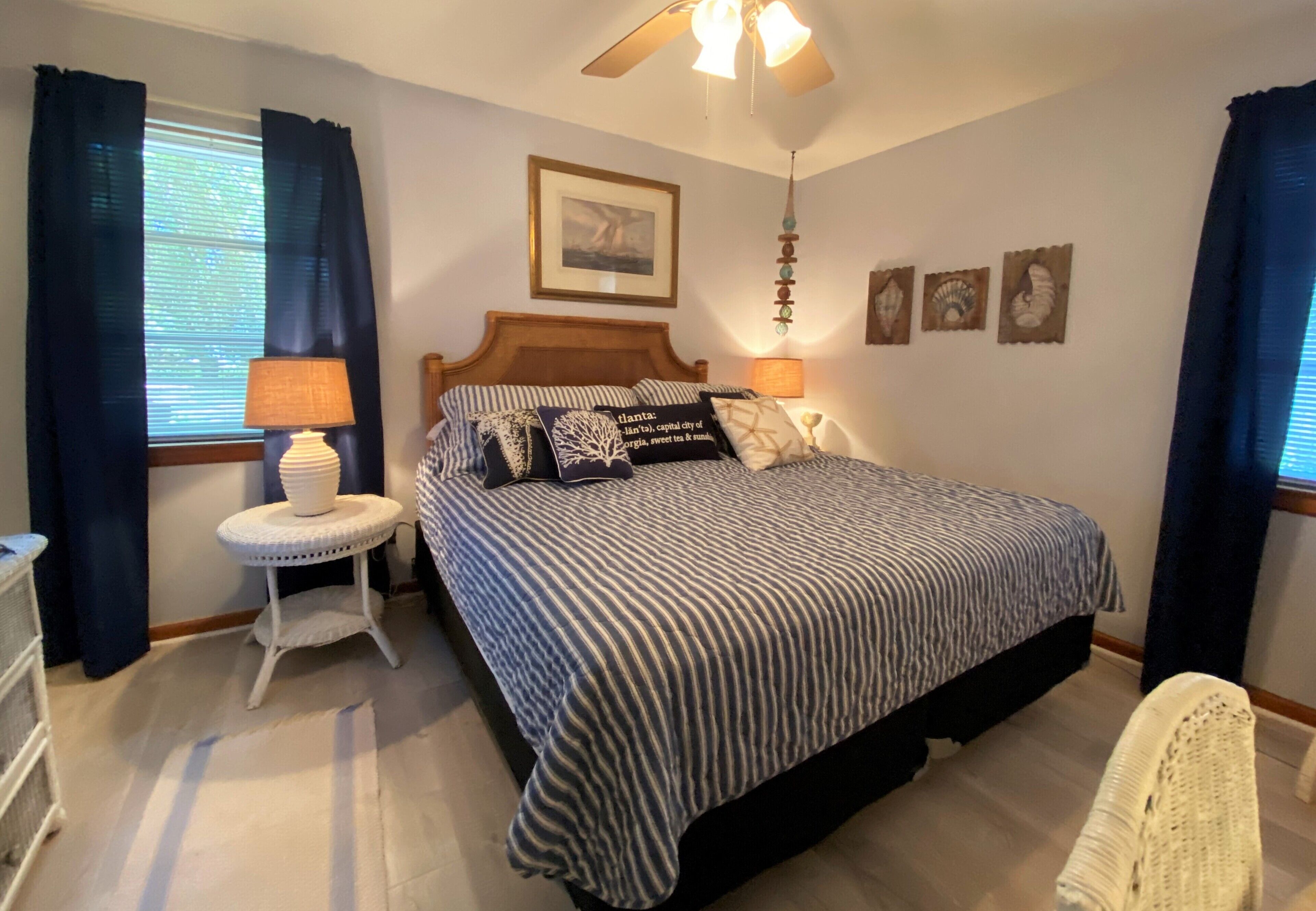 A bedroom with a bed, a nightstand, a lamp, and a ceiling fan.