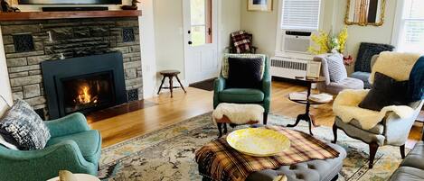 A living room with a fireplace, comfortable seating, and a television.