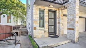 Un edificio moderno con fachada de piedra, una puerta principal y un pequeño porche.
