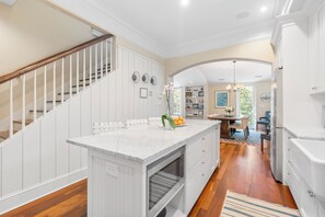 A kitchen with white cabinetry, a marble countertop, and a built-in oven.