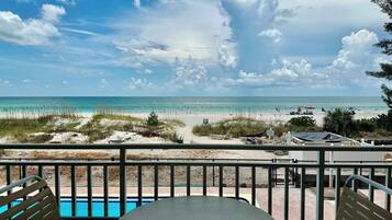 A balcony with a view of a beach and ocean.