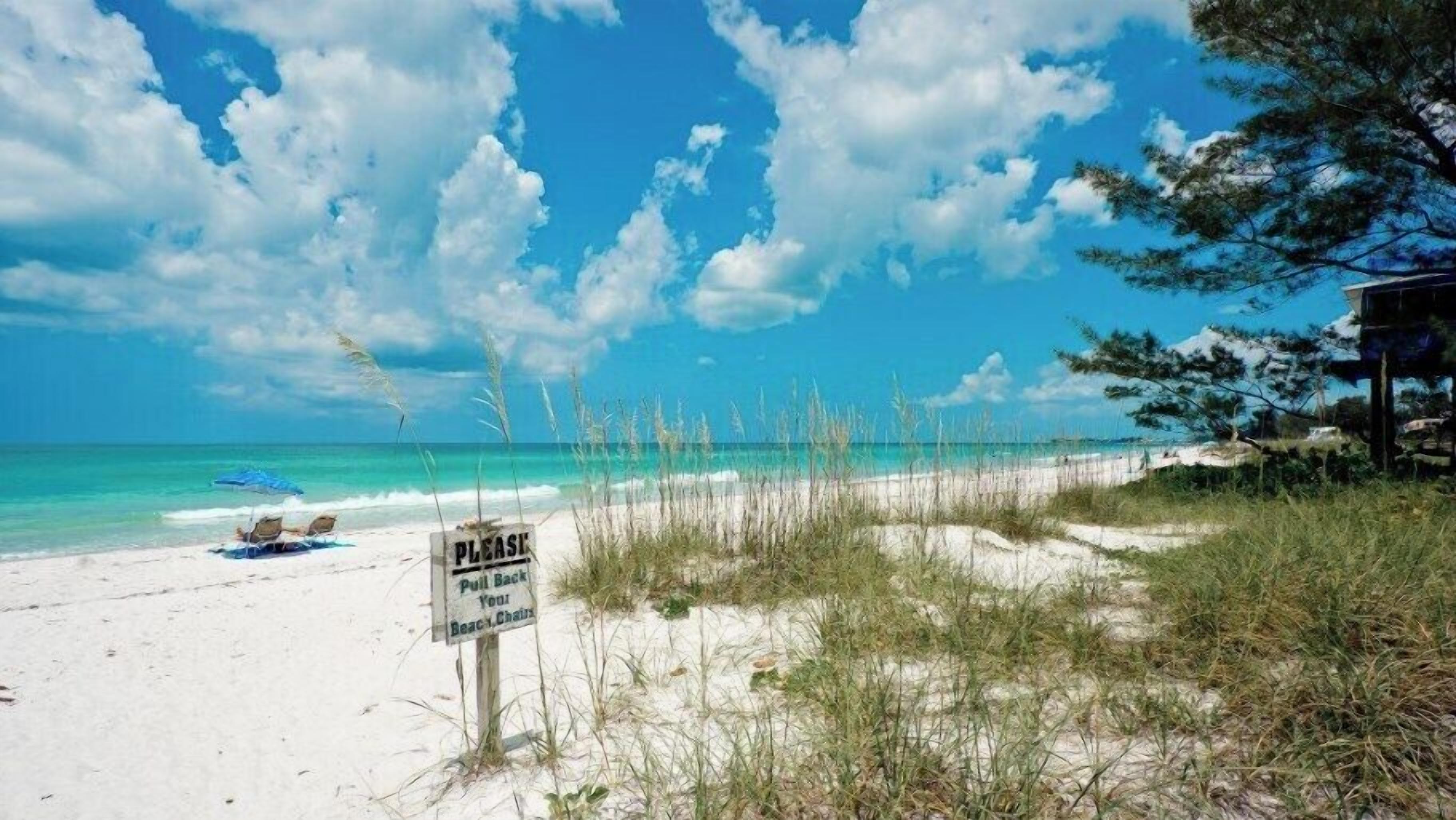 Ein Strand mit einem Schild, das daraufhinweist, den Strandkorb zurückzuziehen.