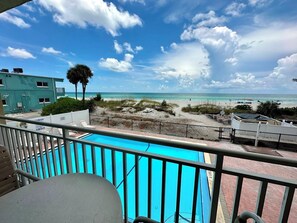 A pool with a view of the beach and ocean.