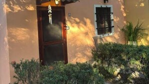 A two-story building with a balcony, a door with a light fixture, and a small window. - Pueblo del Mar 4☙Monkeys & Birds will make your mornings special❧ (Tamarindo)