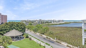 A coastal resort with a gazebo, a road, and beachfront properties.