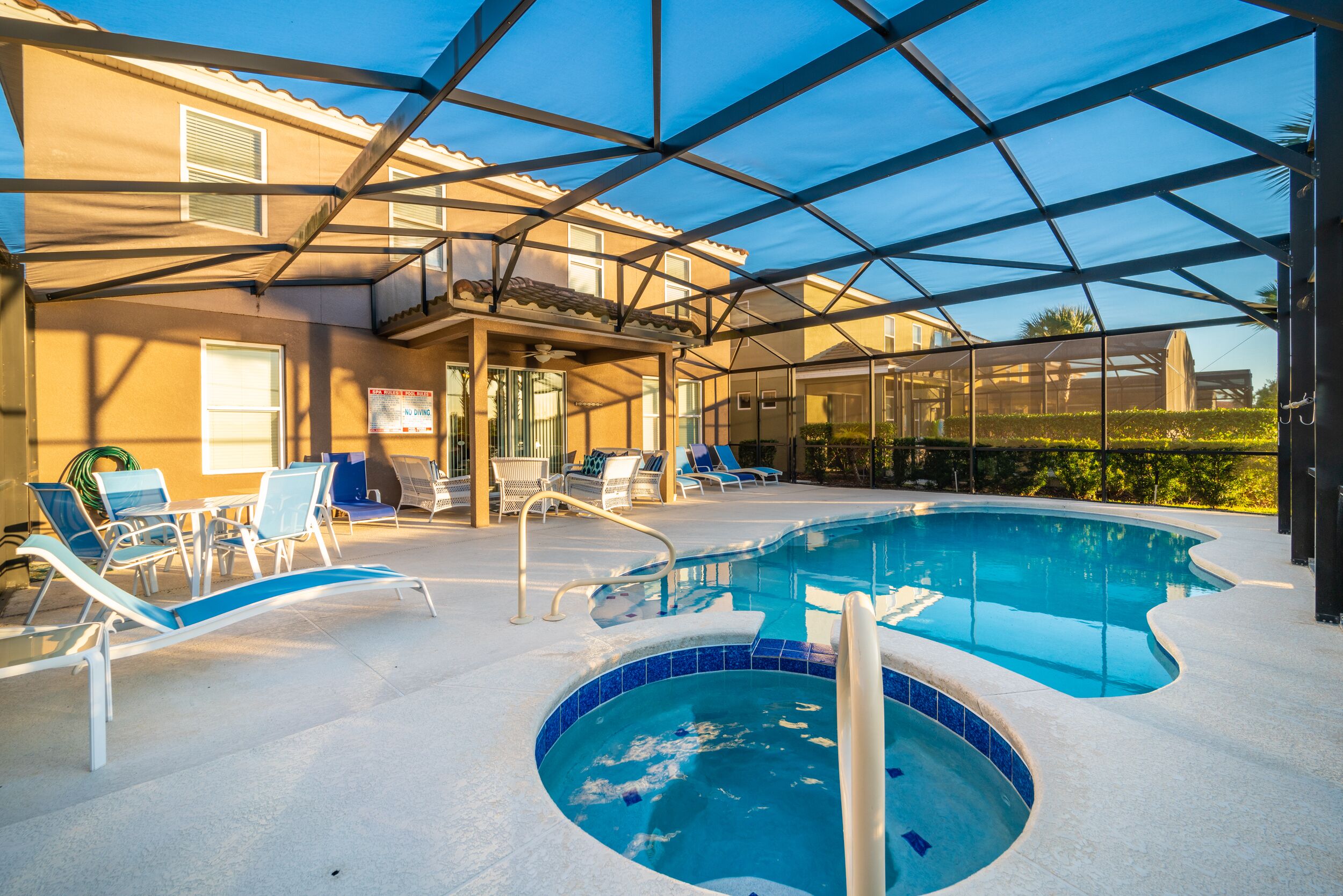 An indoor swimming pool with a sunshade, lounge chairs, and a hot tub.