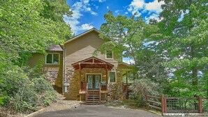 A two-story house with a stone facade, a wooden porch, and a front entrance. - Knockin On Heavens Door: Incredible Views, Theater (Gatlinburg)