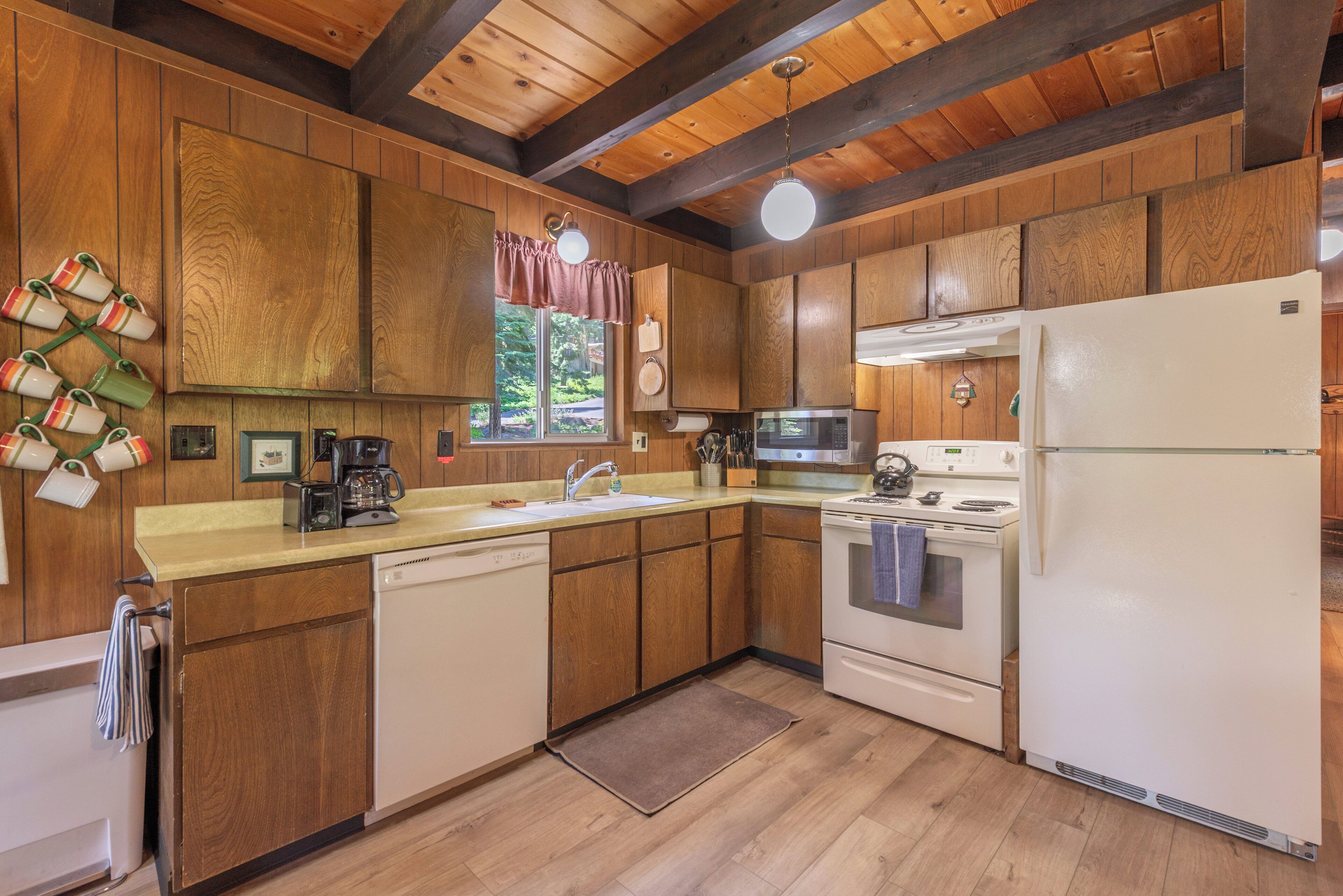 A kitchen with wooden cabinets, a white refrigerator, a stove, and a microwave.
