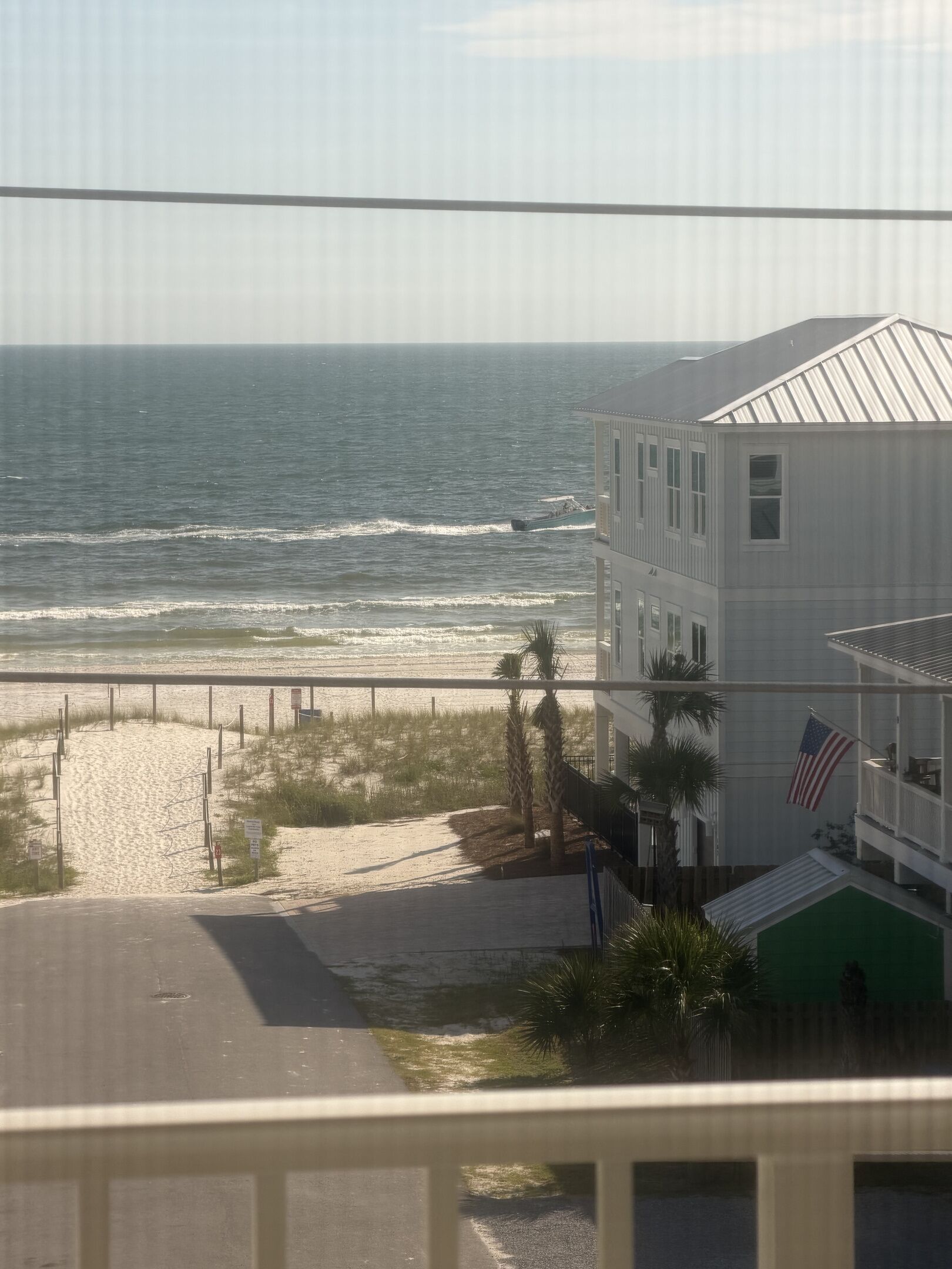 A beach view with a building and a flag.