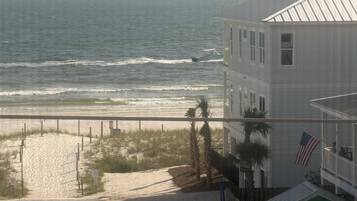 A beach view with a building and a flag.