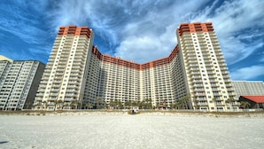 A high-rise hotel with a curved facade, multiple balconies, and a beach view. - 6th Floor Condo with Amazing Views and Free Activities This Summer! (Panama City Beach)