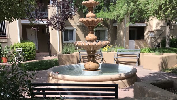 A multi-tiered fountain in a courtyard with a bench in the foreground. - Easy Walk to the Plaza, Gated Retreat, nearby Ski Santa Fe! (Santa Fe)