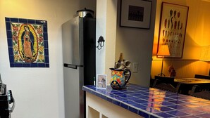 A kitchen with a tiled backsplash, a refrigerator, a small stool, and a wine glass holder. - Easy Walk to the Plaza, Gated Retreat, nearby Ski Santa Fe! (Santa Fe)