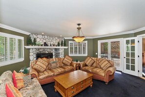 A spacious living room with a fireplace, leather sofas, and a coffee table.