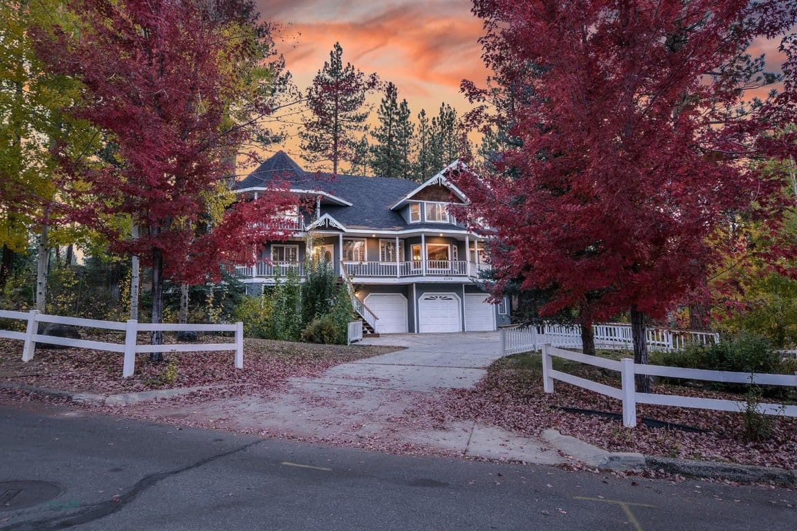 A two-story house with a front porch, garage, and a driveway leading to the entrance.