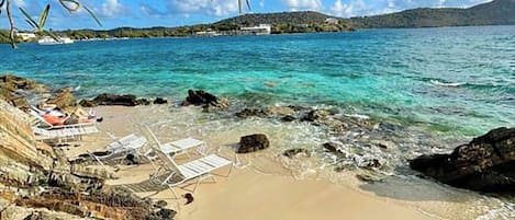 Rannalla, aurinkotuoleja, rantapyyhkeitä