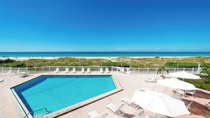 A pool with a view of the beach and ocean.