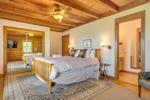 Une chambre à coucher avec un plafond en bois, un lit, une table de chevet, une lampe et un miroir.