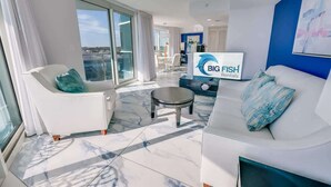 A modern living room with a white sofa, a coffee table, and a TV displaying 'BIG FISH Rentals'.