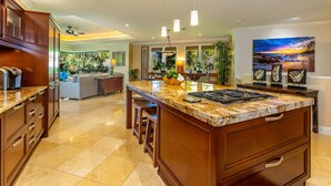 Una cocina amplia con una isla grande, armarios de madera y vistas al exterior.