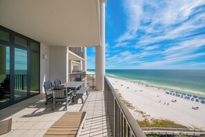 A balcony with a view of the beach and ocean.