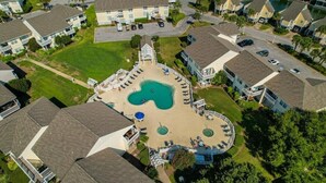 Un quartier résidentiel avec une piscine centrale entourée de maisons.